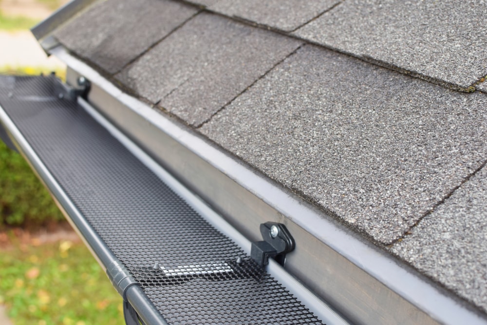 Plastic Guard Mesh Over New Dark Grey Plastic Rain Gutter.